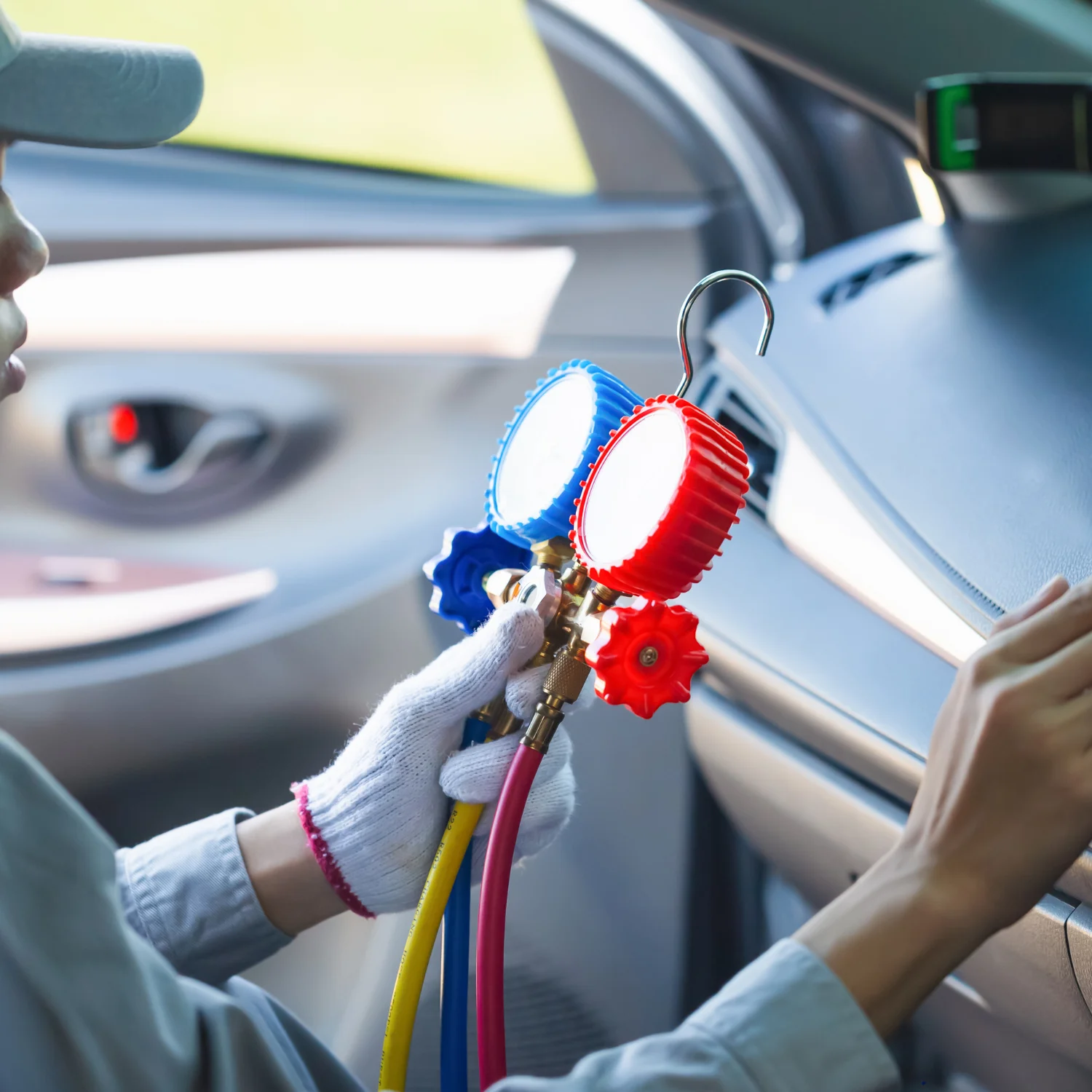 Repairman holding monitor tool to check and fixed car ac system
