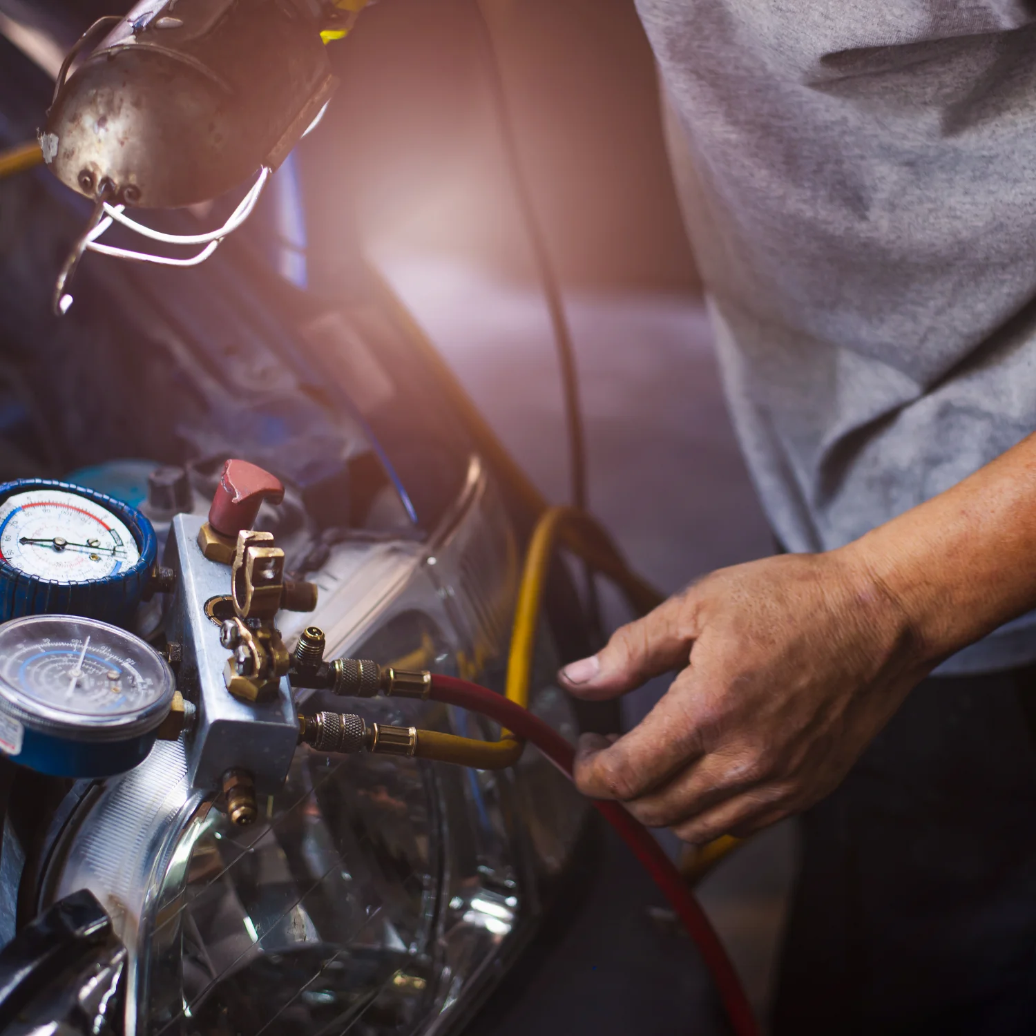 Repairman holding monitor tool to check and fixed car ac system