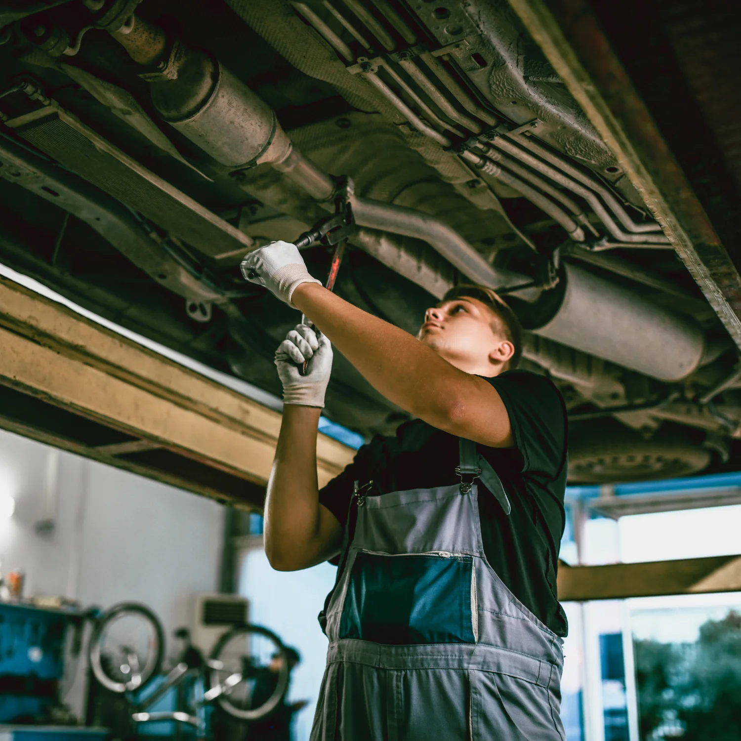 engineer using wrench to fix the car exhaust