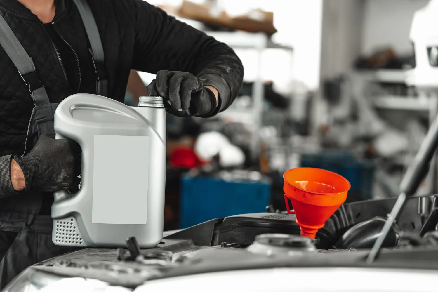 engineer about to pour oil into the engine of the car