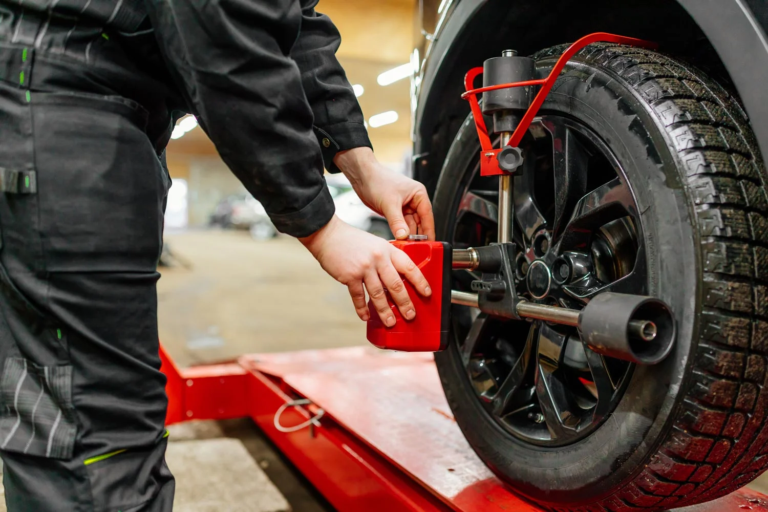 Auto mechanic uses tire balancing machine and turning tire