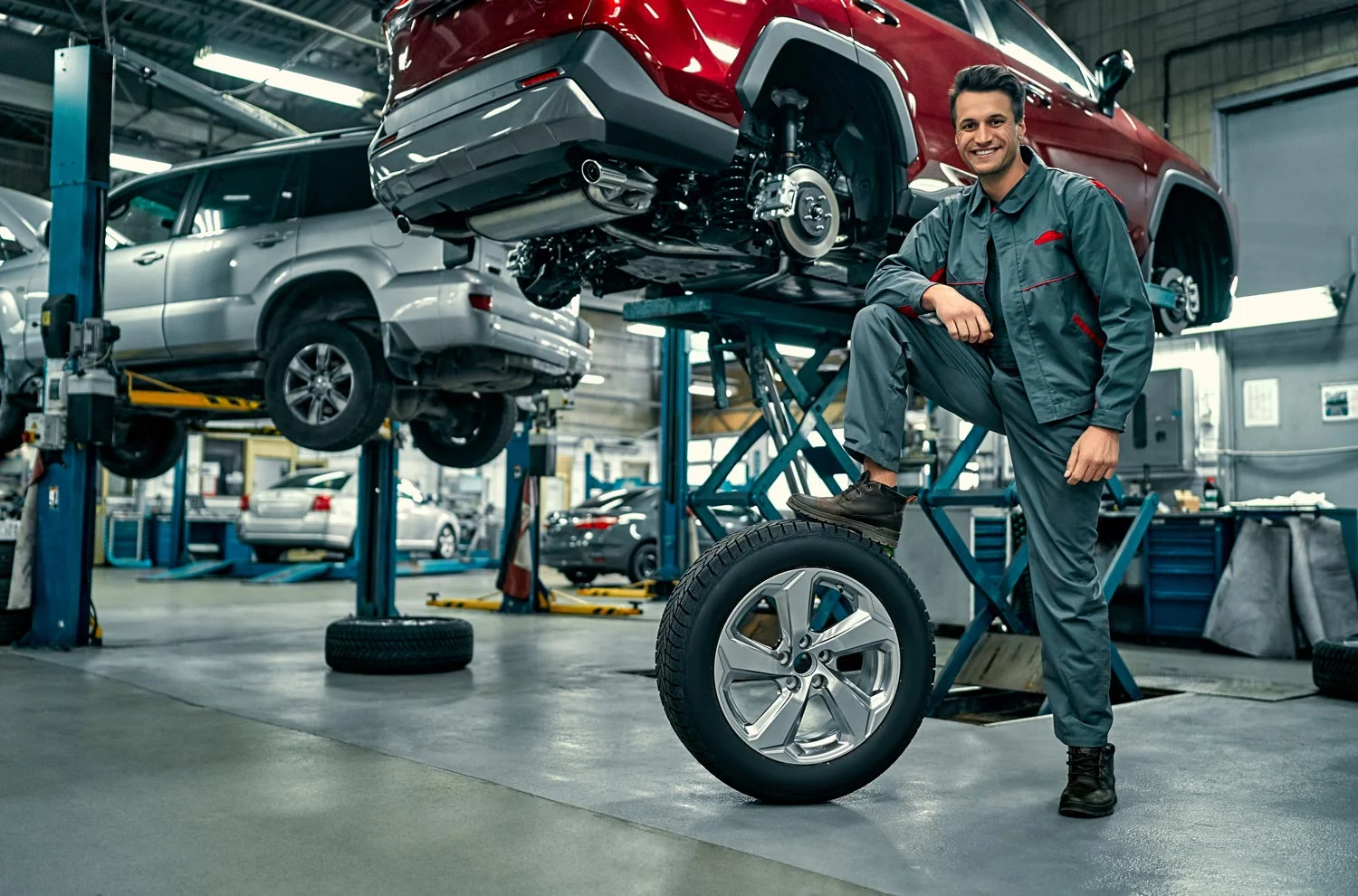 a mechanic standing on the tire at the auto repair shop